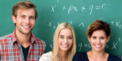 Drei Studierende posieren vor einer mit mathematischen Formeln beschriebenen Tafel