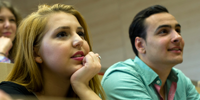 Bild von zwei Studierenden beim Verfolgen einer Vorlesung im Hörsaal