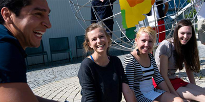 Bild von lachenden Studierenden an der Universität im Freien